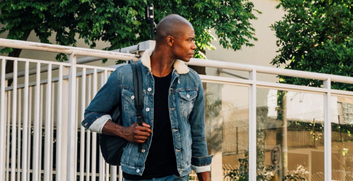 portrait-african-young-man-with-his-backpack-shoulder-looking-away